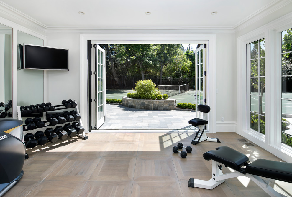 Photo of a traditional home weight room in San Francisco with white walls, light hardwood floors and beige floor.