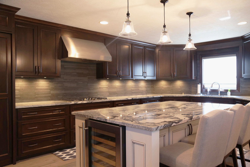 Eat-in kitchen - mid-sized transitional l-shaped porcelain tile eat-in kitchen idea with an undermount sink, raised-panel cabinets, dark wood cabinets, granite countertops, gray backsplash, porcelain backsplash, stainless steel appliances and an island