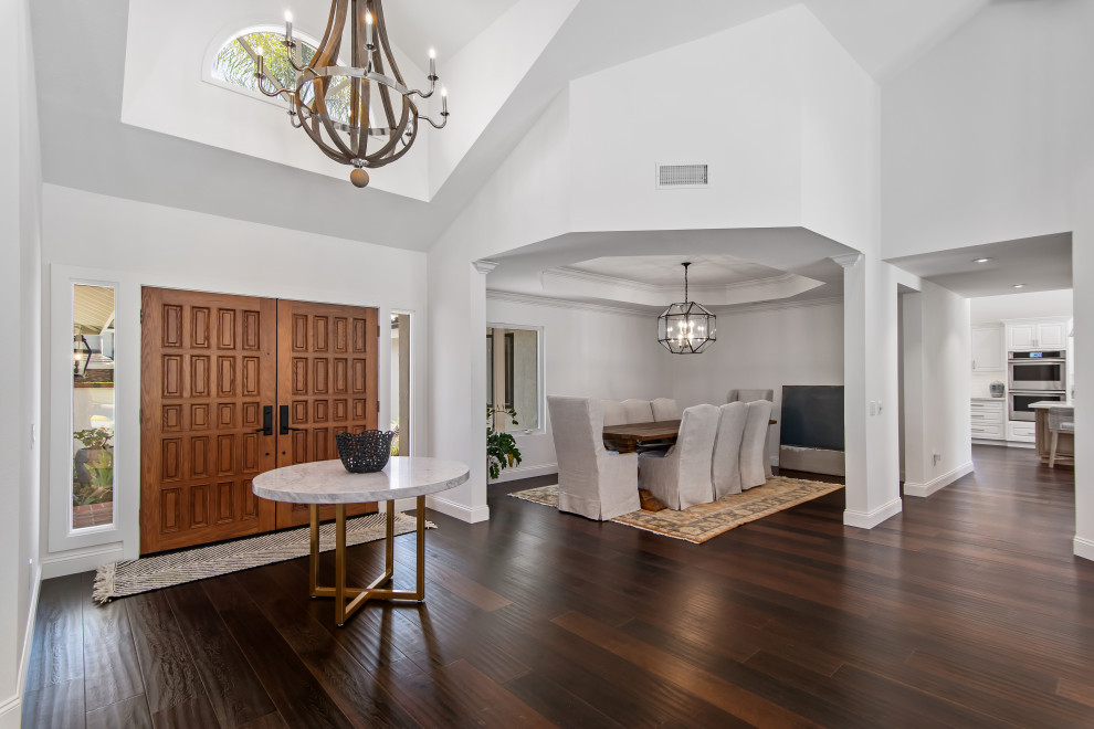 Inspiration for a mid-sized contemporary foyer in Orange County with white walls, dark hardwood floors, a double front door, a brown front door, brown floor and vaulted.