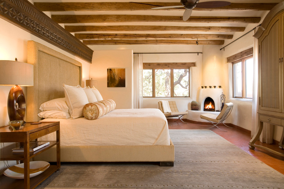 Photo of a large master bedroom in Albuquerque with beige walls, a corner fireplace and a plaster fireplace surround.