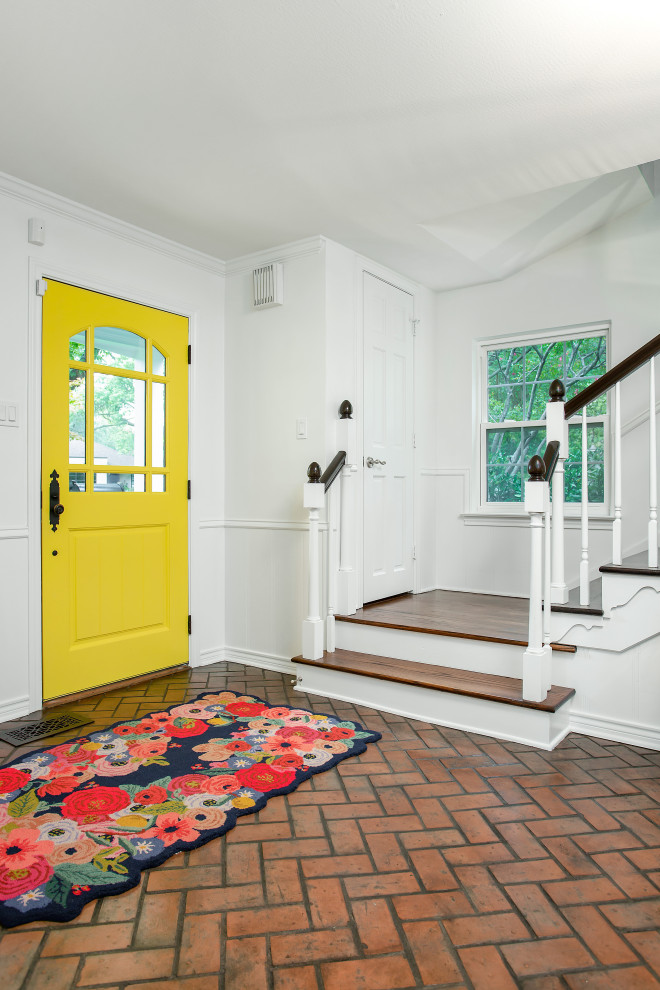 На фото: фойе среднего размера в стиле шебби-шик с белыми стенами, кирпичным полом, одностворчатой входной дверью, желтой входной дверью и красным полом с