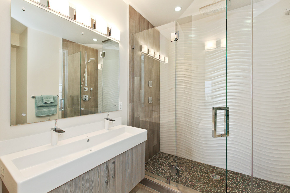 Photo of a contemporary bathroom in San Francisco with a trough sink, flat-panel cabinets, an alcove shower and pebble tile floors.