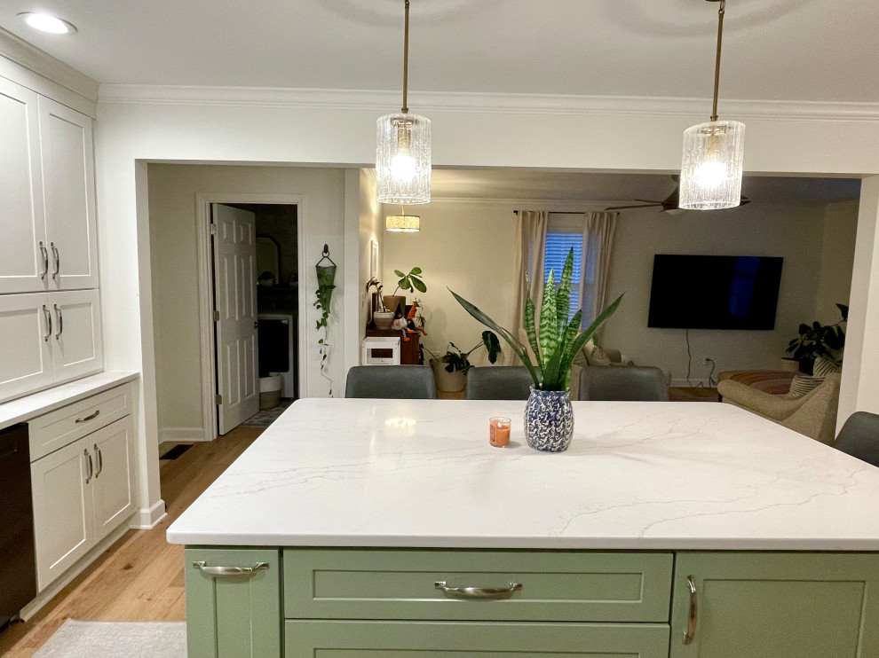 Eat-in kitchen - transitional l-shaped light wood floor and beige floor eat-in kitchen idea with a farmhouse sink, shaker cabinets, white cabinets, quartz countertops, white backsplash, quartz backsplash, black appliances, an island and white countertops