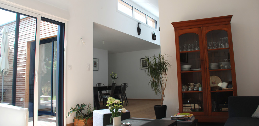 Idée de décoration pour une salle de séjour design ouverte et de taille moyenne avec un mur blanc et parquet clair.