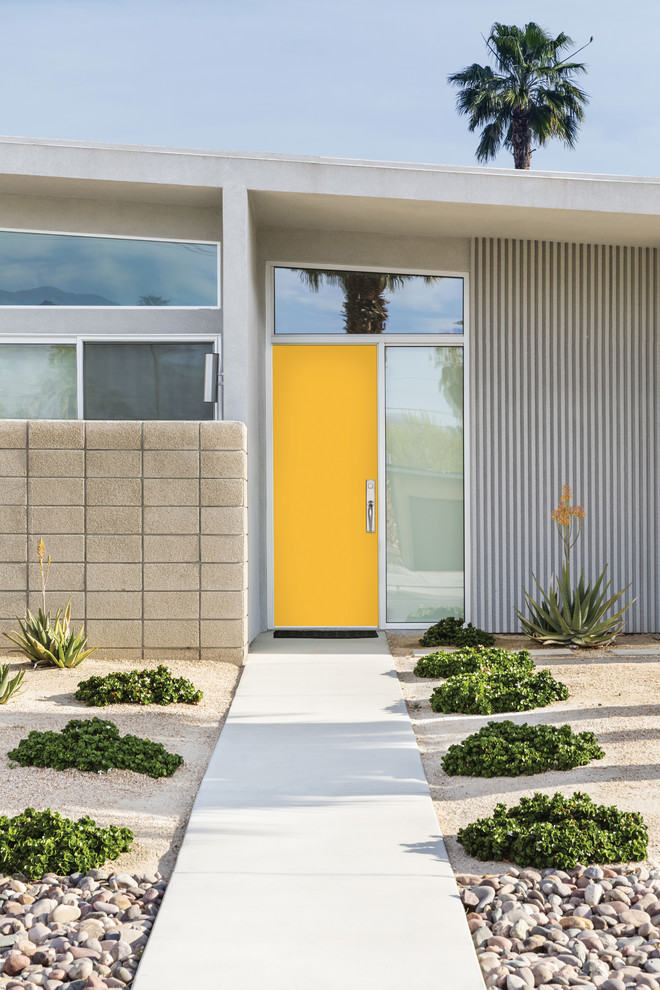This is an example of a large midcentury one-storey grey house exterior in Los Angeles with mixed siding.