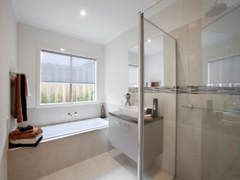 Mid-sized contemporary bathroom in Melbourne with beige cabinets, solid surface benchtops, a drop-in tub, a corner shower, beige tile, porcelain tile, white walls and porcelain floors.