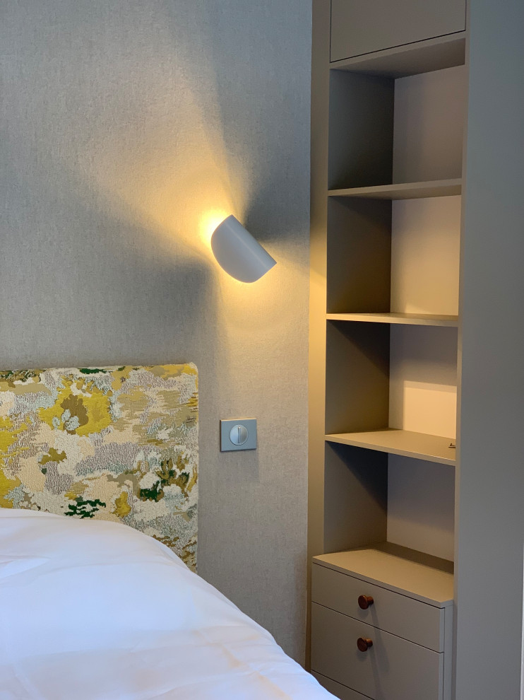 Modelo de dormitorio principal actual de tamaño medio con paredes beige, moqueta, suelo beige, papel pintado y papel pintado
