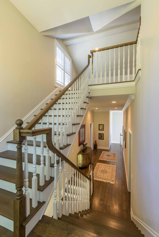 Inspiration for a mid-sized traditional wood straight staircase in Chicago with painted wood risers, wood railing and wallpaper.