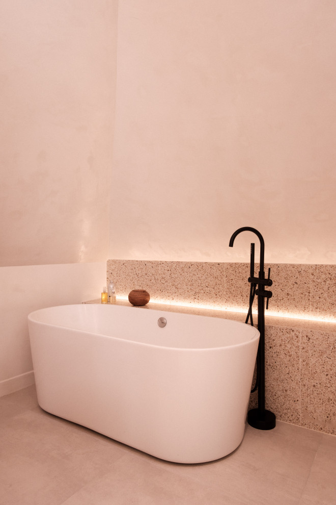 Aménagement d'une salle de bain beige et blanche contemporaine en bois clair de taille moyenne avec une baignoire posée, une douche à l'italienne, WC séparés, un carrelage beige, un mur beige, un lavabo posé, un sol beige, aucune cabine, un plan de toilette blanc, un banc de douche, meuble double vasque et meuble-lavabo suspendu.