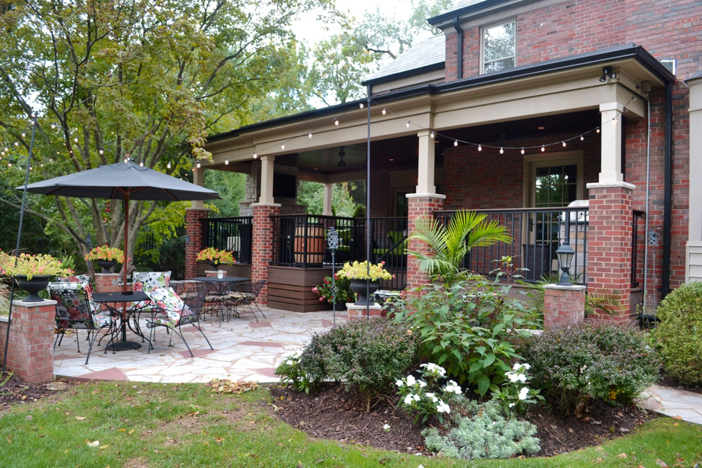 Large eclectic back ground level metal railing terrace in St Louis with a fireplace and a roof extension.