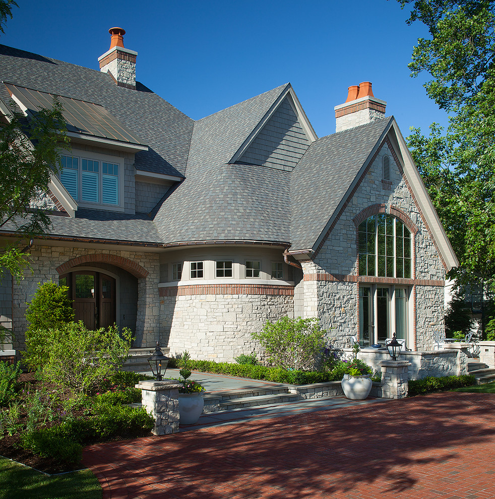 Expansive traditional three-storey grey house exterior in Grand Rapids with mixed siding, a mixed roof and a gable roof.