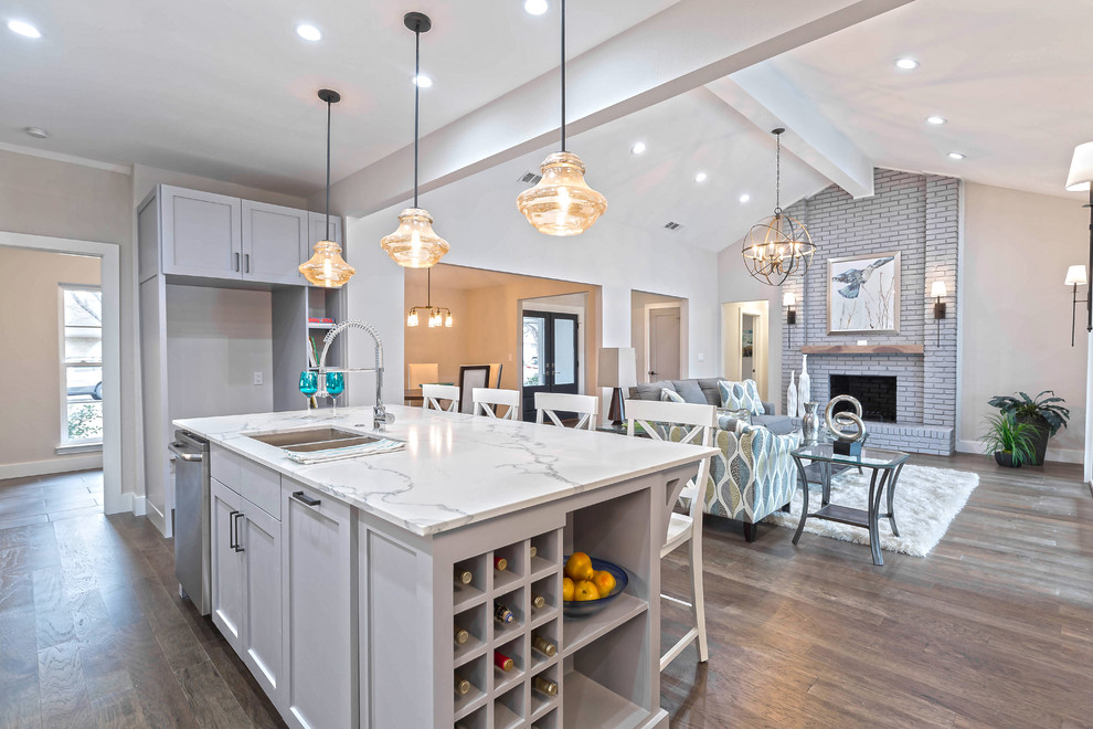 Mid-sized transitional galley medium tone wood floor open concept kitchen photo in Dallas with a double-bowl sink, shaker cabinets, gray cabinets, quartz countertops, white backsplash, subway tile backsplash, stainless steel appliances and an island