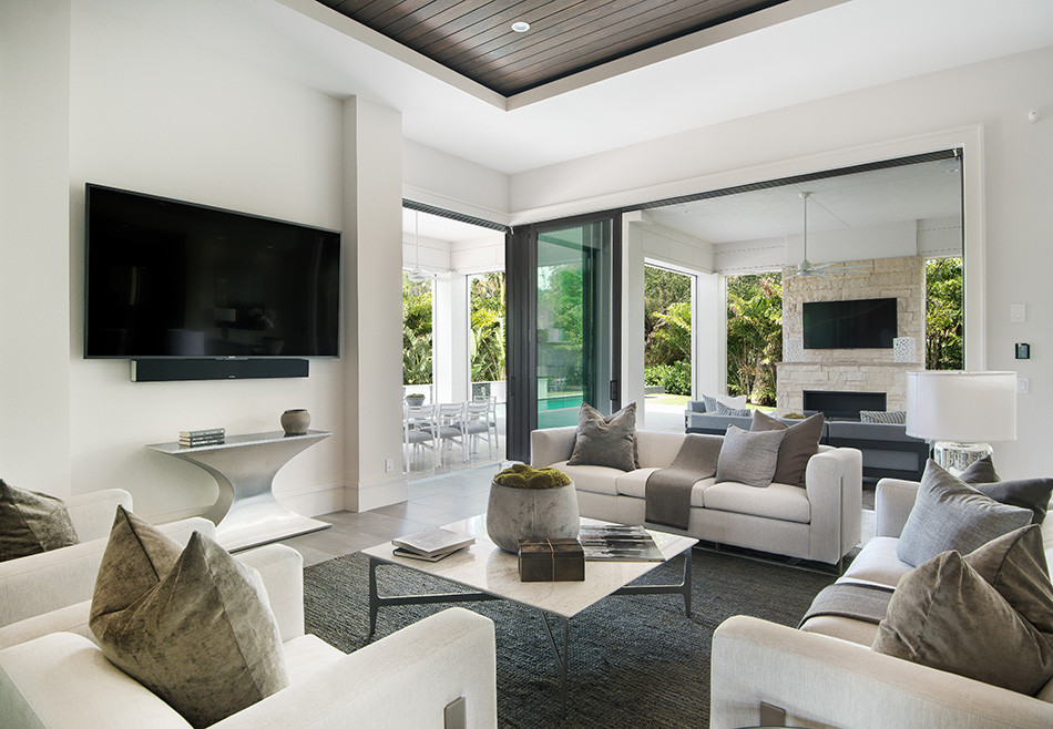 Großes, Offenes Maritimes Wohnzimmer mit beiger Wandfarbe, TV-Wand, braunem Boden und Holzdielendecke in Sonstige