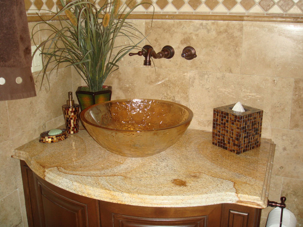 Inspiration for a mid-sized traditional 3/4 bathroom in Atlanta with a vessel sink, recessed-panel cabinets, medium wood cabinets, granite benchtops, a freestanding tub, a double shower, a one-piece toilet, beige tile, cement tile, beige walls and travertine floors.