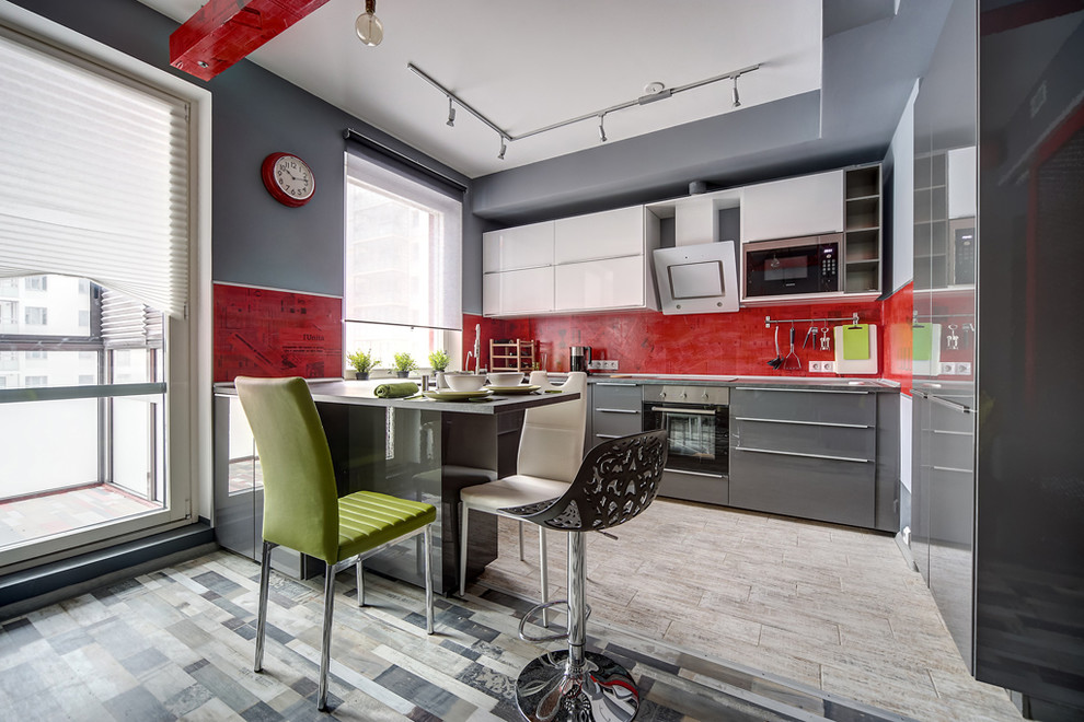 Design ideas for a contemporary u-shaped open plan kitchen in Saint Petersburg with flat-panel cabinets, grey cabinets, red splashback, stainless steel appliances and a breakfast bar.