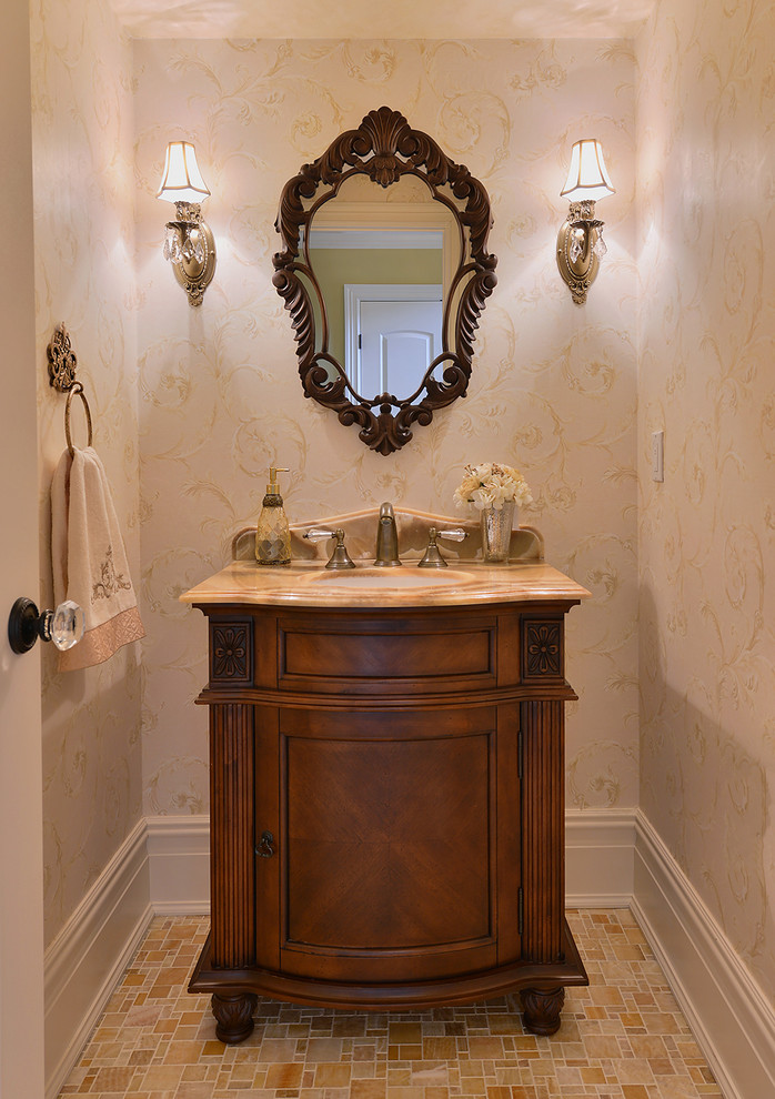 This is an example of a small powder room in New York with an undermount sink, furniture-like cabinets, medium wood cabinets, onyx benchtops, stone tile, beige walls, mosaic tile floors and beige tile.