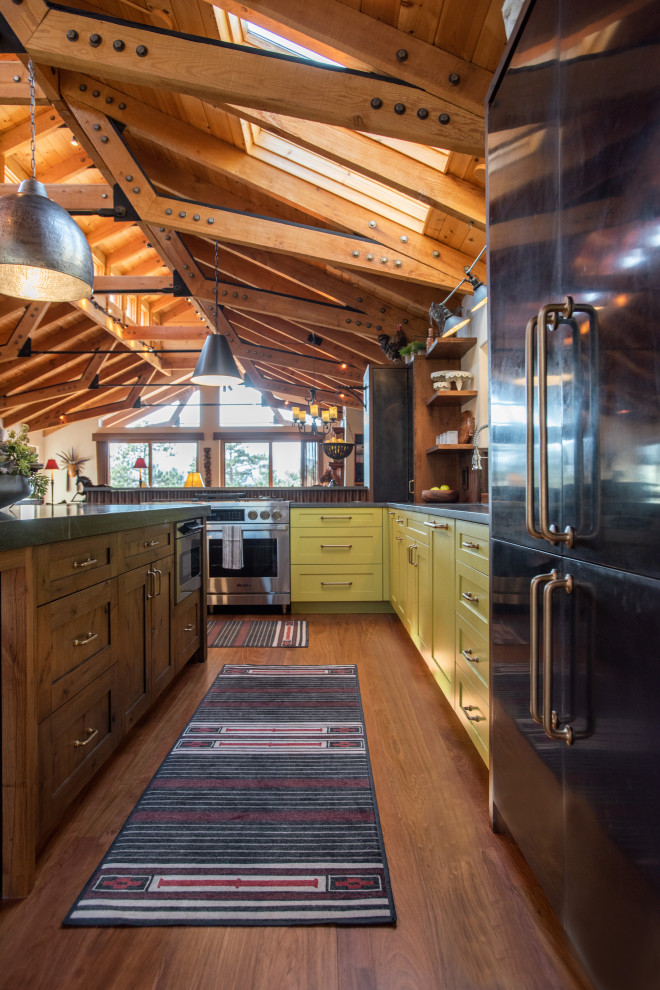 Design ideas for a large country l-shaped eat-in kitchen in Denver with shaker cabinets, green cabinets, soapstone benchtops, metallic splashback, medium hardwood floors, multiple islands, black benchtop and exposed beam.