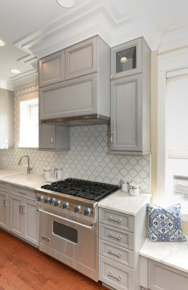 Mid-sized transitional l-shaped medium tone wood floor eat-in kitchen photo in Chicago with recessed-panel cabinets, gray cabinets, multicolored backsplash, an island, an undermount sink, quartzite countertops, mosaic tile backsplash and stainless steel appliances