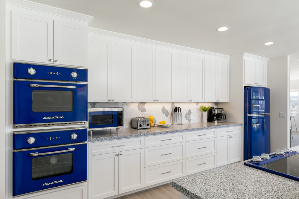 Inspiration for a large transitional single-wall eat-in kitchen in San Diego with an undermount sink, raised-panel cabinets, white cabinets, granite benchtops, multi-coloured splashback, ceramic splashback, coloured appliances, porcelain floors, with island, beige floor and blue benchtop.