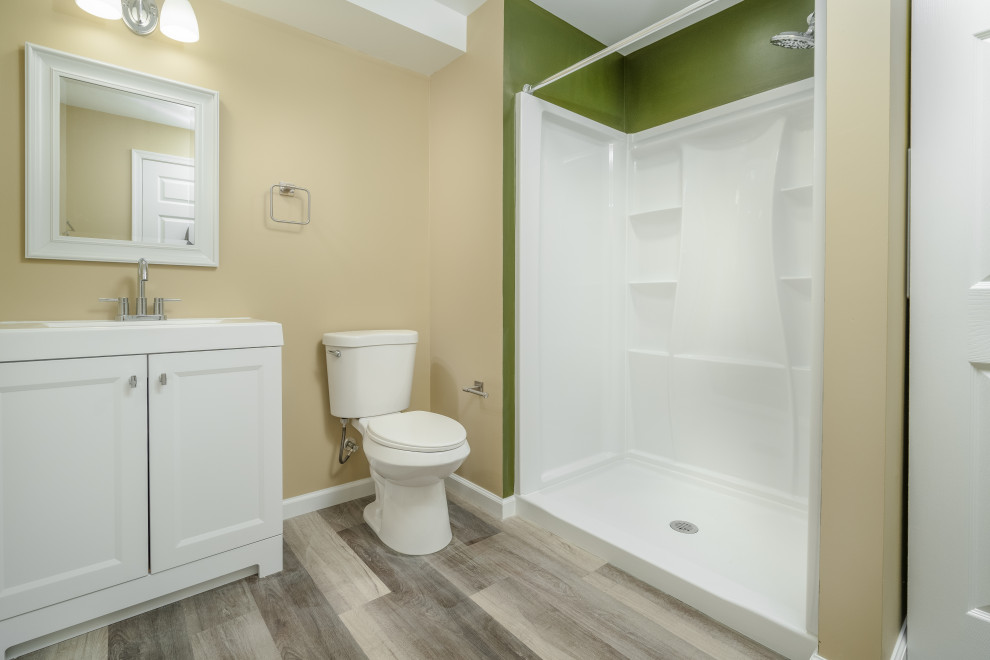 Photo of a mid-sized modern 3/4 bathroom in DC Metro with shaker cabinets, white cabinets, an open shower, a two-piece toilet, beige walls, vinyl floors, an integrated sink, marble benchtops, multi-coloured floor, a shower curtain, white benchtops, a single vanity and a freestanding vanity.
