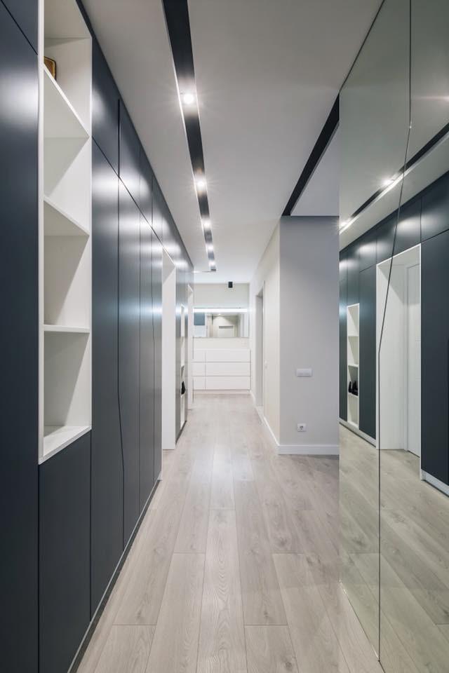 Photo of a mid-sized contemporary hallway in Other with beige walls, laminate floors and grey floor.