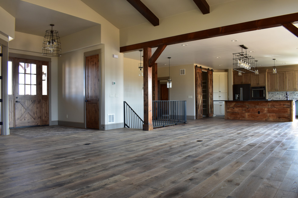 Design ideas for a mid-sized country foyer in Denver with beige walls, medium hardwood floors, a single front door, a medium wood front door and exposed beam.