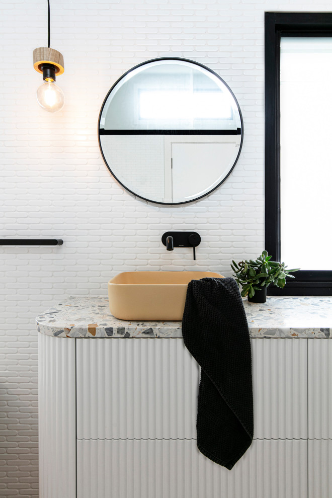 Источник вдохновения для домашнего уюта: детская ванная комната среднего размера в морском стиле с белыми фасадами, накладной ванной, душем над ванной, раздельным унитазом, белой плиткой, керамической плиткой, белыми стенами, полом из керамической плитки, настольной раковиной, столешницей терраццо, коричневым полом, открытым душем, разноцветной столешницей, сиденьем для душа, тумбой под две раковины, подвесной тумбой и сводчатым потолком