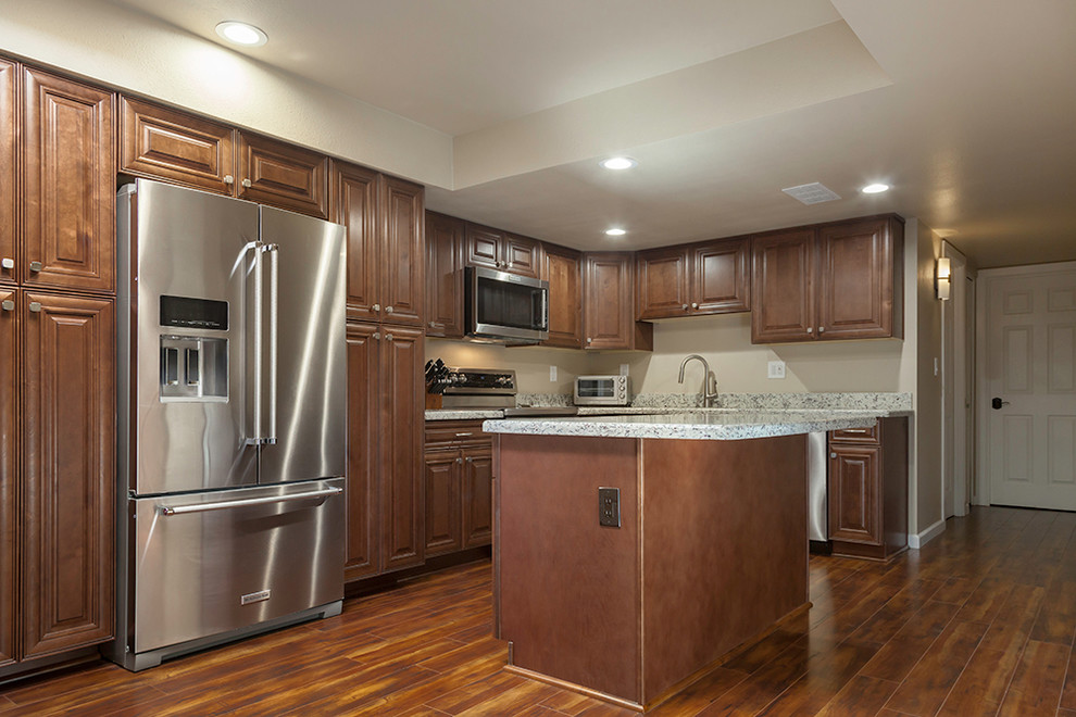 Enclosed kitchen - mid-sized transitional l-shaped laminate floor and brown floor enclosed kitchen idea in Phoenix with an undermount sink, shaker cabinets, medium tone wood cabinets, granite countertops, multicolored backsplash, stone slab backsplash, stainless steel appliances and an island