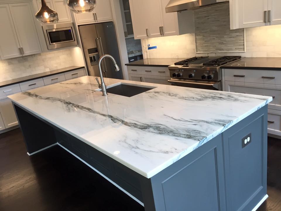 Open concept kitchen - mid-sized transitional single-wall dark wood floor and brown floor open concept kitchen idea in Dallas with recessed-panel cabinets, white cabinets, marble countertops, white backsplash, stone tile backsplash, stainless steel appliances, an island and an undermount sink