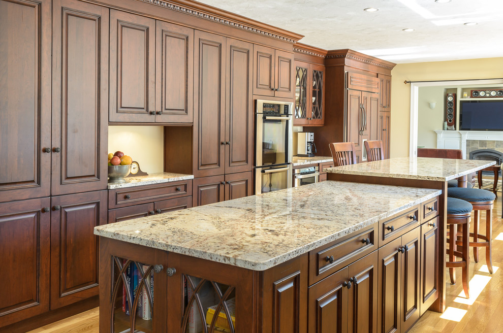 Inspiration for a traditional galley eat-in kitchen in Boston with an undermount sink, raised-panel cabinets, brown cabinets, granite benchtops and stainless steel appliances.
