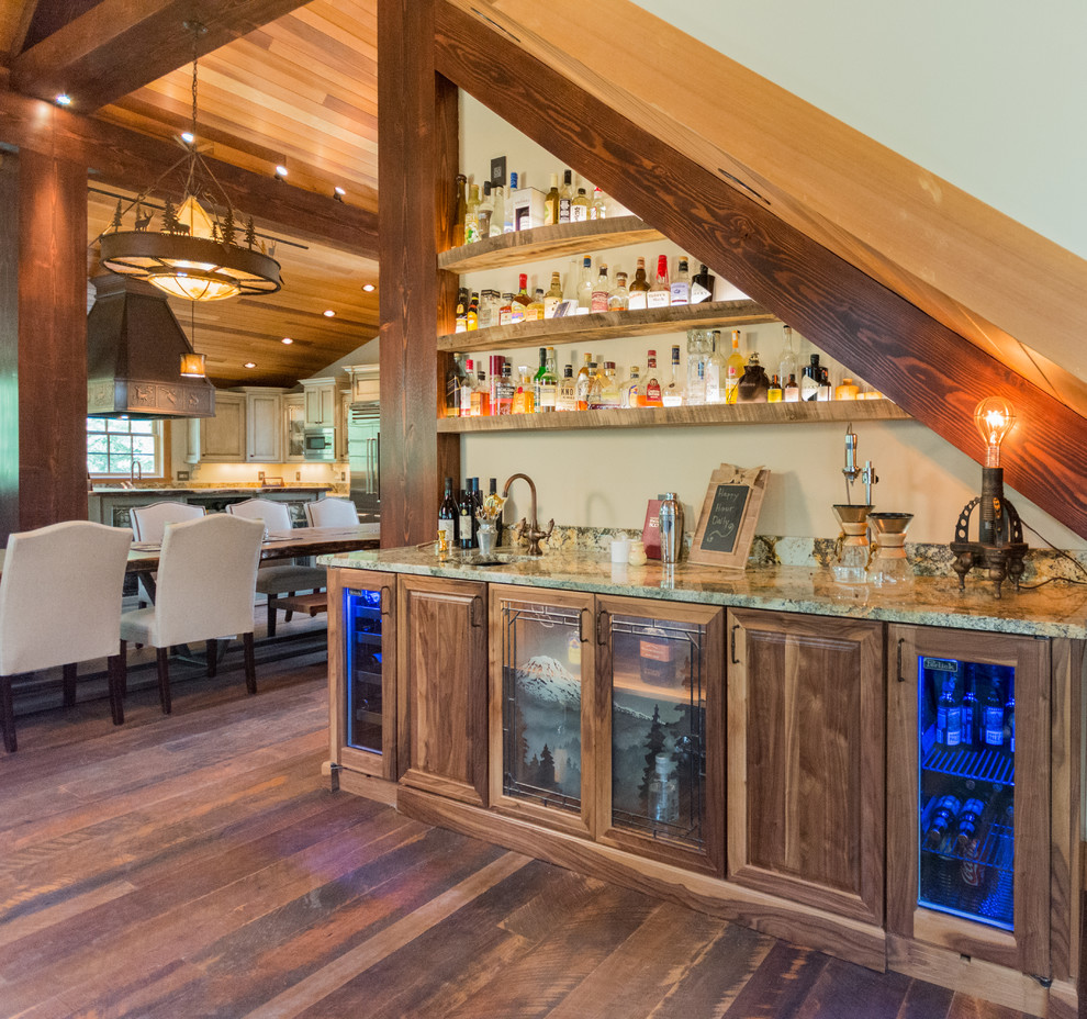 Large country single-wall home bar in Portland with recessed-panel cabinets, distressed cabinets, granite benchtops, stone slab splashback and dark hardwood floors.