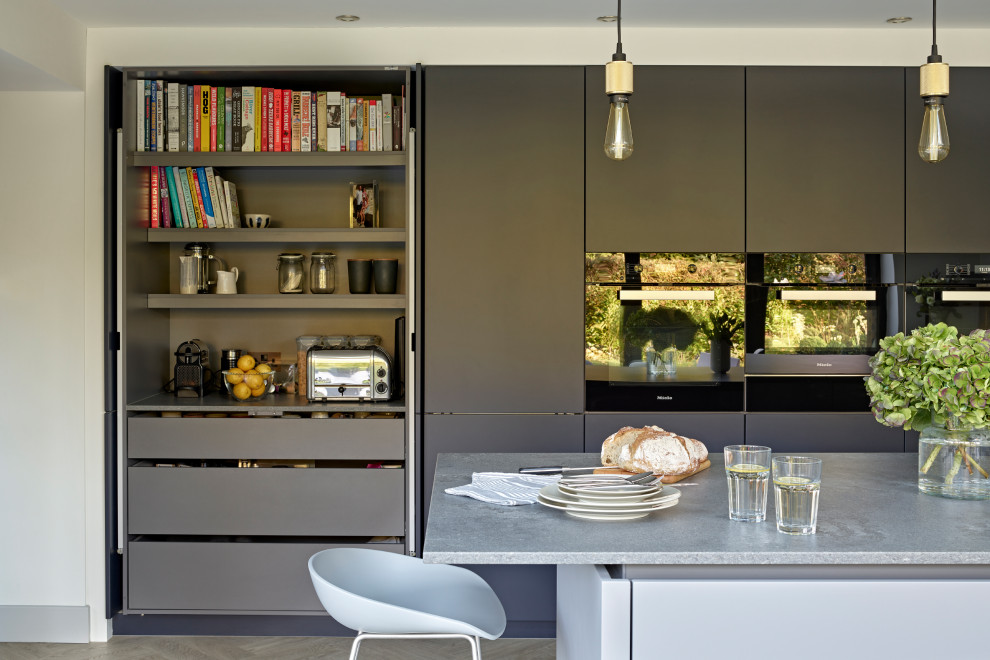 Design ideas for a large contemporary l-shaped eat-in kitchen in Surrey with an undermount sink, flat-panel cabinets, grey cabinets, quartzite benchtops, metallic splashback, mirror splashback, vinyl floors, with island and grey benchtop.