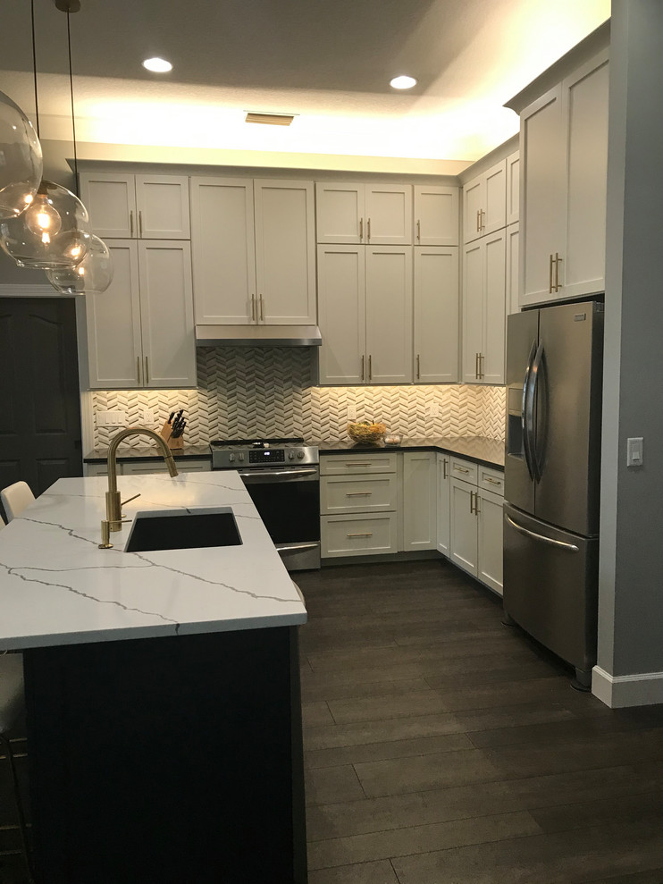 Inspiration for a huge transitional l-shaped vinyl floor and brown floor open concept kitchen remodel in Baltimore with an undermount sink, shaker cabinets, white cabinets, quartz countertops, white backsplash, marble backsplash, stainless steel appliances, an island and multicolored countertops