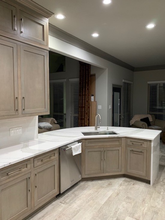 Large traditional l-shaped eat-in kitchen in Houston with a drop-in sink, recessed-panel cabinets, distressed cabinets, marble benchtops, white splashback, ceramic splashback, stainless steel appliances, light hardwood floors, with island, beige floor and white benchtop.