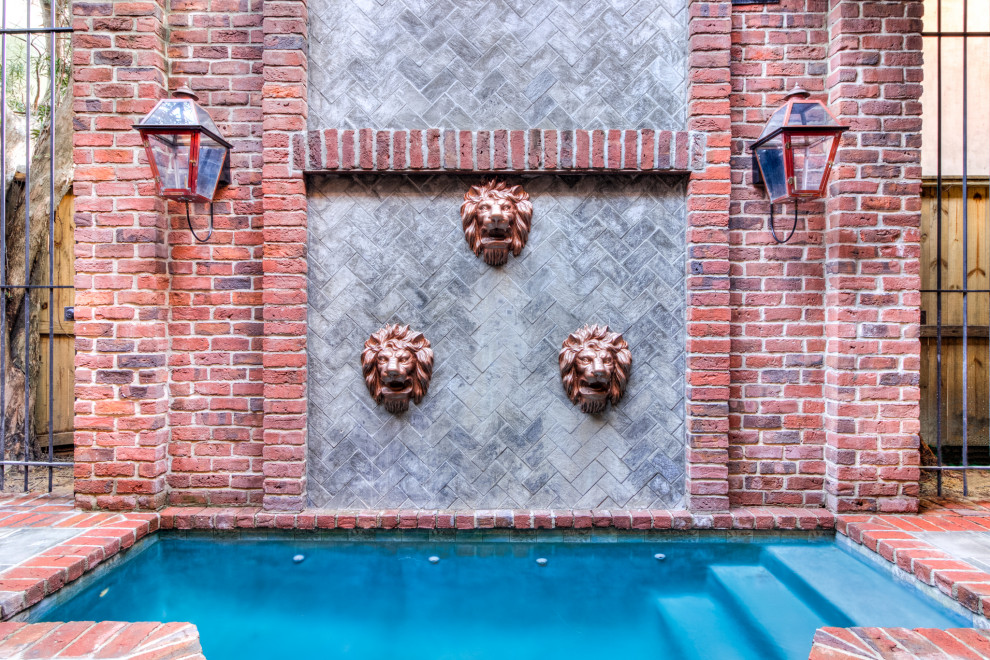 Inspiration for a small transitional backyard custom-shaped pool in Houston with natural stone pavers.