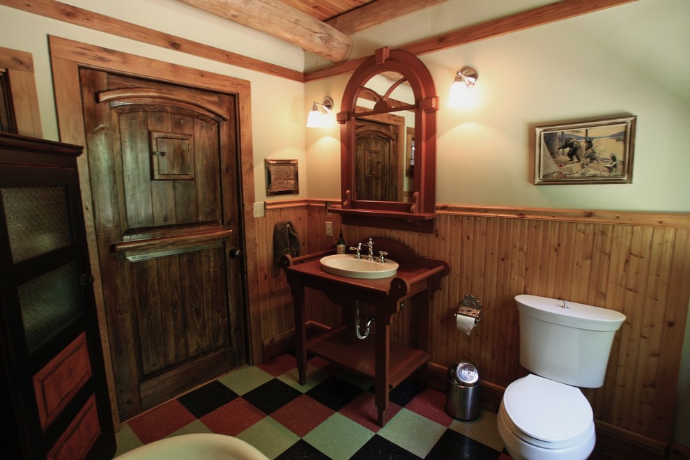 Freestanding bathtub - large rustic 3/4 linoleum floor freestanding bathtub idea with recessed-panel cabinets, beige walls, a pedestal sink and solid surface countertops