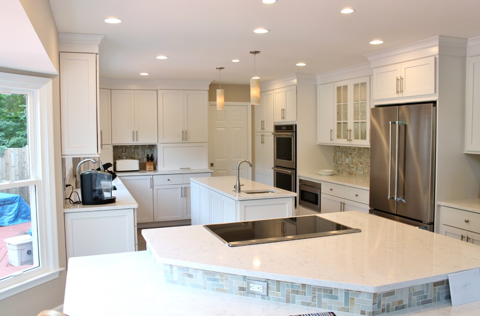 Inspiration for a large transitional eat-in kitchen in DC Metro with an undermount sink, white cabinets, beige splashback, stainless steel appliances, multiple islands, shaker cabinets, quartzite benchtops, stone tile splashback, porcelain floors and brown floor.