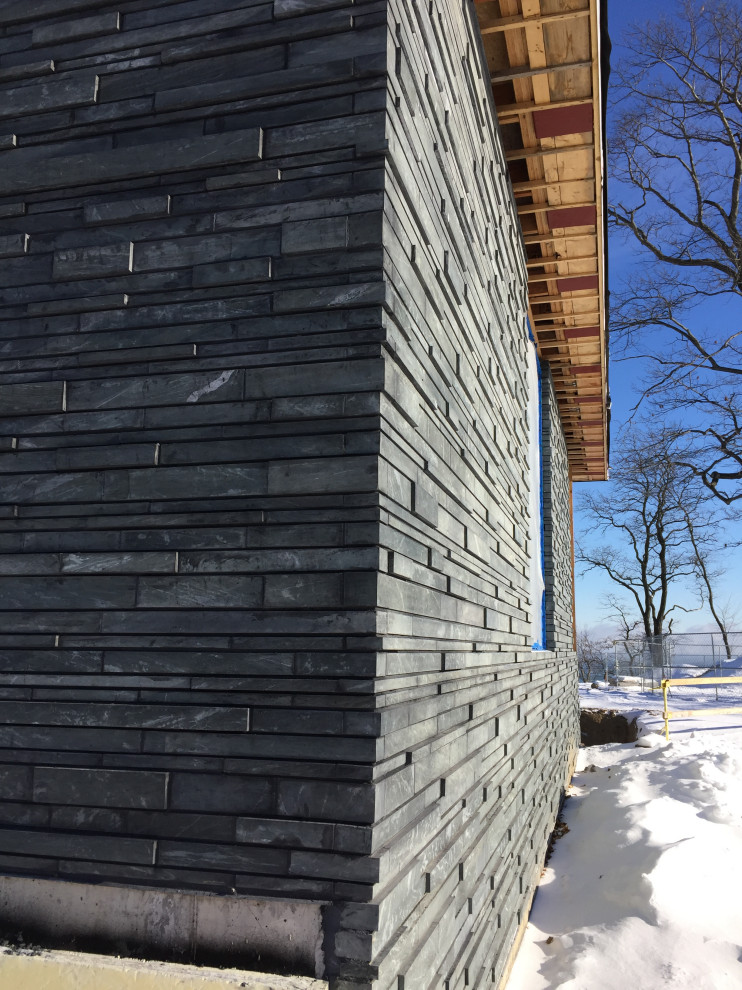 Inspiration for a large contemporary black house exterior in Chicago with stone veneer.