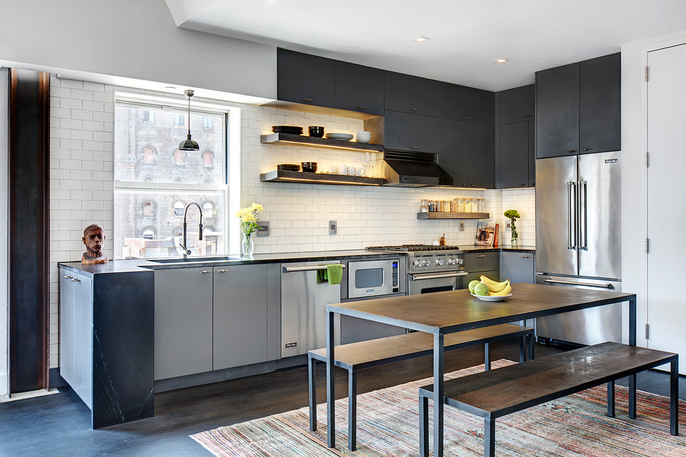 Example of an urban kitchen design in New York with flat-panel cabinets, black cabinets, white backsplash, subway tile backsplash and no island