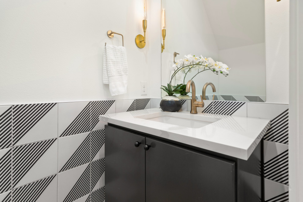 Immagine di un piccolo bagno di servizio minimal con ante lisce, ante nere, pistrelle in bianco e nero, pareti bianche, lavabo sottopiano e top bianco