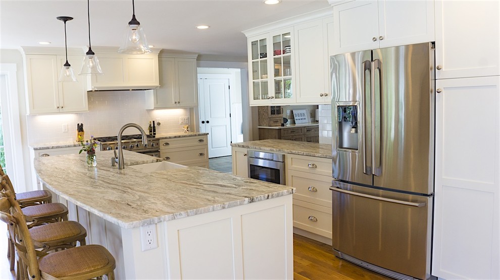 Mid-sized transitional galley dark wood floor and brown floor open concept kitchen photo in Boston with a farmhouse sink, shaker cabinets, white cabinets, granite countertops, white backsplash, subway tile backsplash, stainless steel appliances and an island