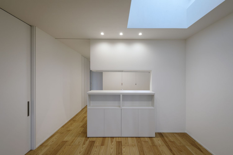 Immagine di un'ampia sala da pranzo moderna chiusa con pareti bianche, pavimento in legno verniciato, pavimento beige e carta da parati