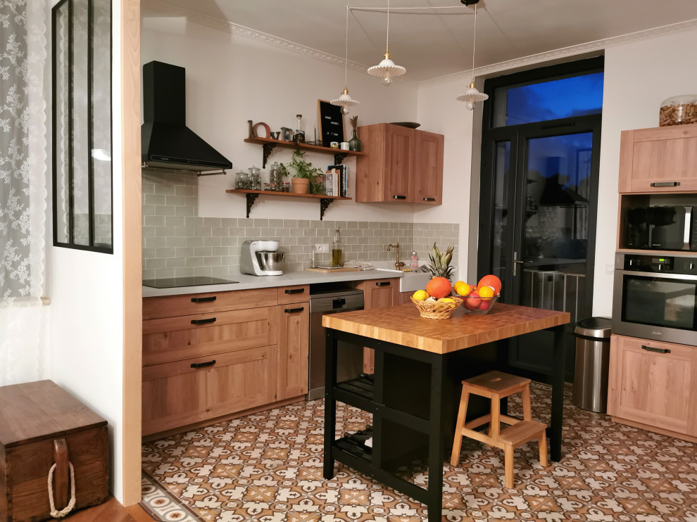 Inspiration for a mid-sized midcentury l-shaped open plan kitchen in Marseille with a farmhouse sink, beaded inset cabinets, light wood cabinets, laminate benchtops, green splashback, subway tile splashback, stainless steel appliances, cement tiles, with island, multi-coloured floor and white benchtop.