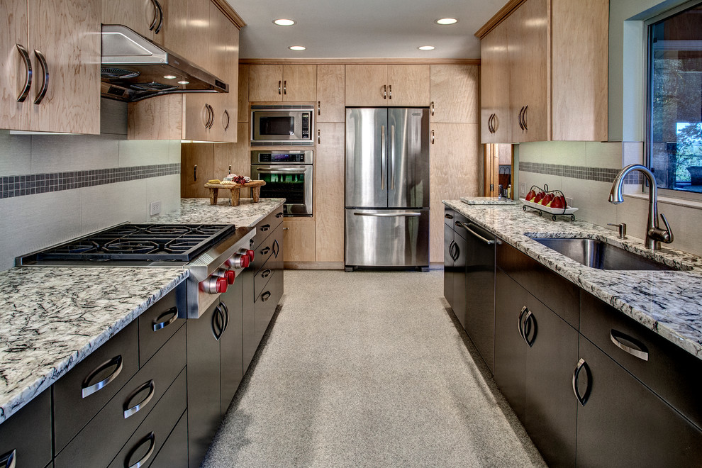 This is an example of a contemporary galley separate kitchen in Seattle with an undermount sink, flat-panel cabinets, dark wood cabinets, granite benchtops, grey splashback, stainless steel appliances and porcelain splashback.
