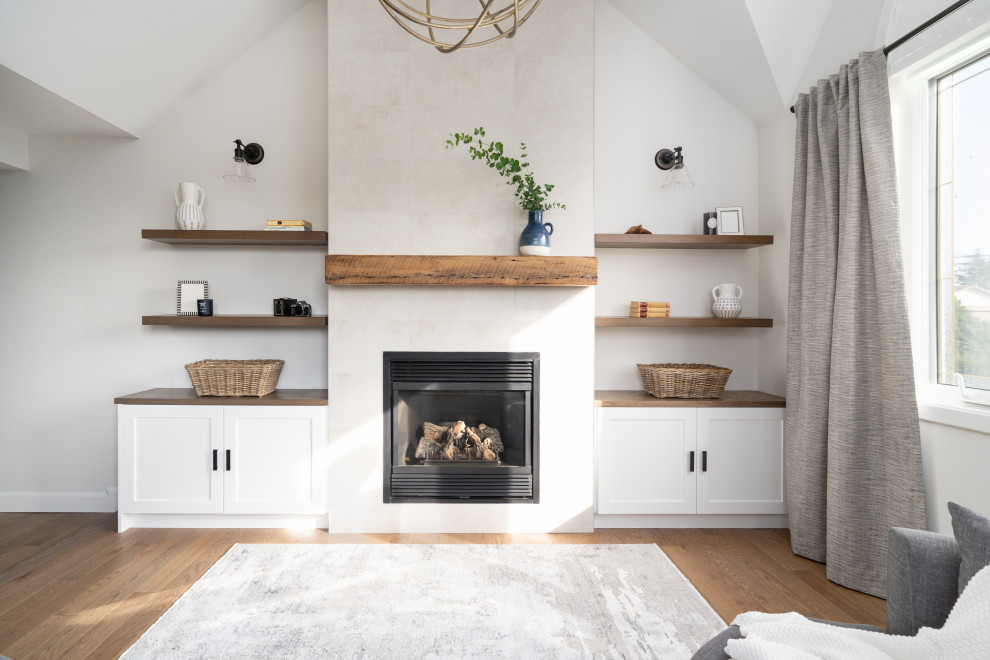 Idées déco pour une très grande chambre parentale contemporaine avec un mur gris, parquet clair, une cheminée standard, un manteau de cheminée en pierre de parement, un sol marron et un plafond voûté.