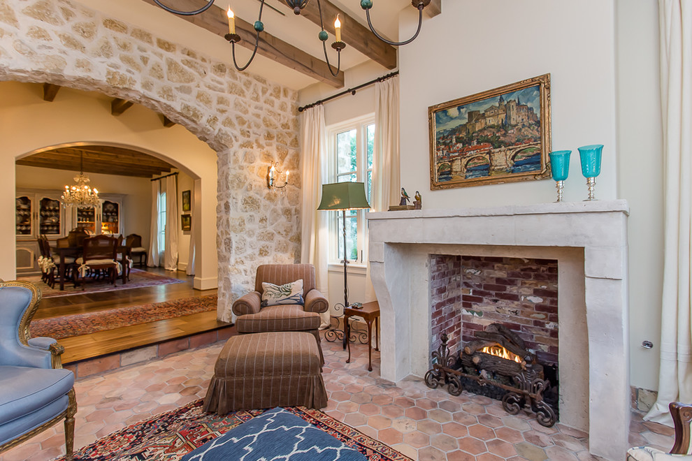 Inspiration for a mid-sized mediterranean formal open concept living room in Houston with beige walls, terra-cotta floors, a standard fireplace, a stone fireplace surround and no tv.