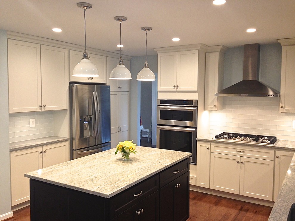 Design ideas for a large transitional kitchen in Baltimore with an undermount sink, shaker cabinets, white cabinets, granite benchtops, white splashback, glass tile splashback, stainless steel appliances, dark hardwood floors and with island.