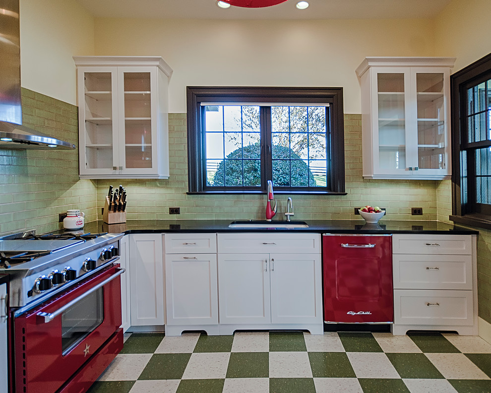 Mid-sized midcentury l-shaped eat-in kitchen in DC Metro with an undermount sink, shaker cabinets, white cabinets, green splashback, coloured appliances, linoleum floors and with island.