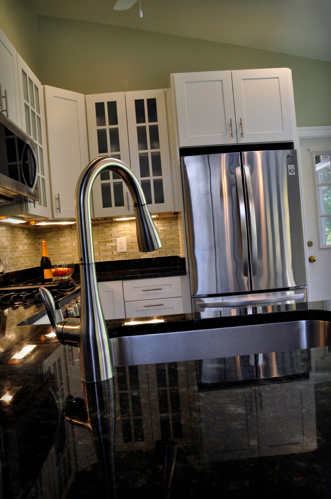 Eat-in kitchen - mid-sized transitional u-shaped dark wood floor eat-in kitchen idea in DC Metro with an undermount sink, shaker cabinets, white cabinets, granite countertops, yellow backsplash, glass tile backsplash, stainless steel appliances and a peninsula