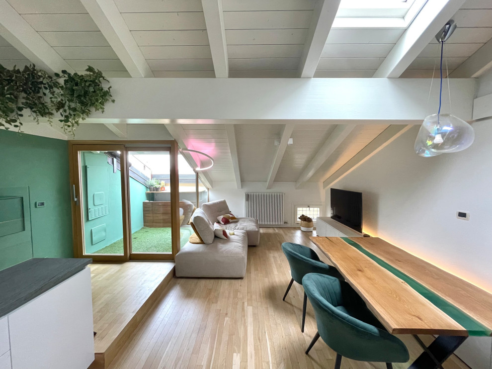 Foto di una piccola sala da pranzo aperta verso il soggiorno minimalista con pareti verdi, pavimento in legno massello medio, pavimento marrone, travi a vista e boiserie
